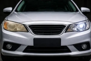 השוואה בין פנס רכב ימני עכור ומצהיב לבין פנס רכב שמאלי שחודש למצב מבריק ושקוף – מדריך Zemaze לחידוש פנסים.