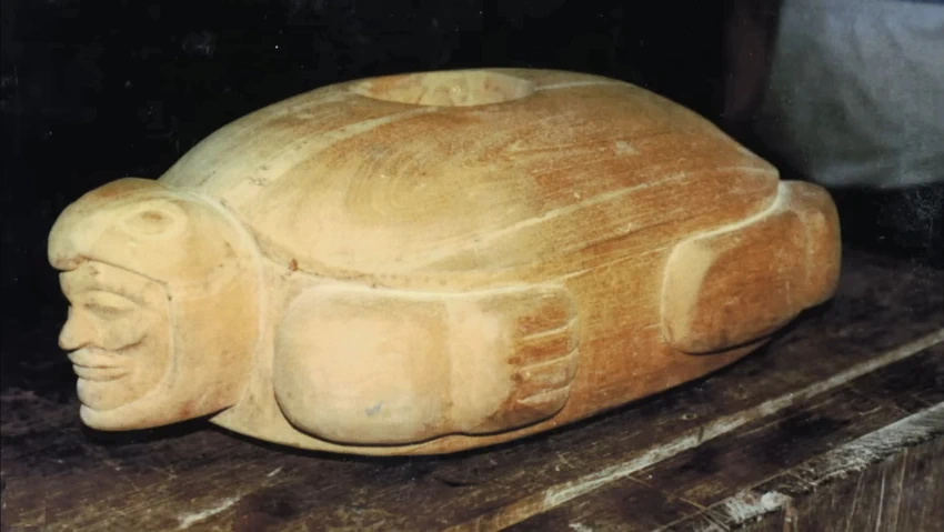 צלמית חרס עתיקה מגואטמלה המציגה דמות אנושית הלובשת שריון אווירודינמי ומשקפיים, המכונה 'צב מעופף' לפי האגדה המקומית.