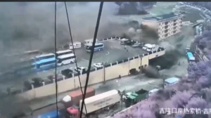 תיעוד ממצלמת אבטחה רגע לפני שגל עצום של אדמה, בוץ ופסולת פוגע במבנה רב-קומות ובמתחם חניה עמוס באוטובוסים ומשאיות באזור מעבר הגבול ג'ירונג.